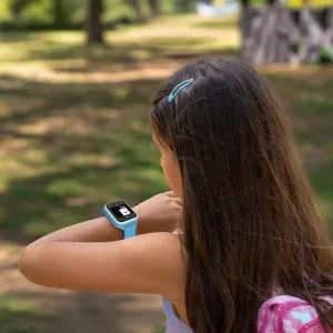 myFirst Fone M1 smartklokke for barn på et barns håndledd utendørs, med blå reim og GPS-sporing