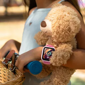 myFirst smartklokke for barn i rosa på håndleddet til et barn, vist utendørs med en teddybjørn