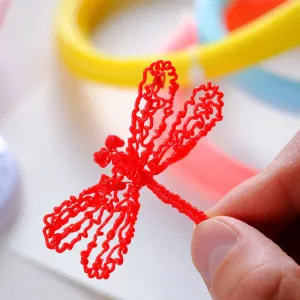 myFirst-kreasjon med 3D-penn: rødt 3D-printet insekt i øyenstikkerstil holdt i hånden med fargerike løkker