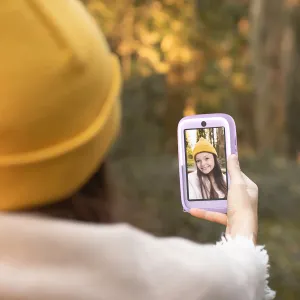 myFirst Camera 50 lila barnkamera som hålls utomhus och visar en selfie på skärmen