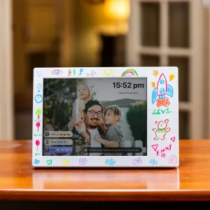 myFirst Frame Doodle 9 digital fotoram med klotterkant, som visar ett familjefoto på ett vitt stativ