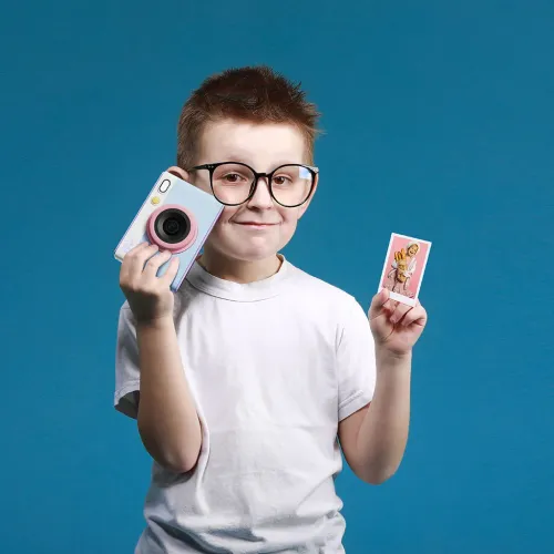 myFirst Insta Lux instant camera held by a child, with a printed photo, in pastel blue and pink